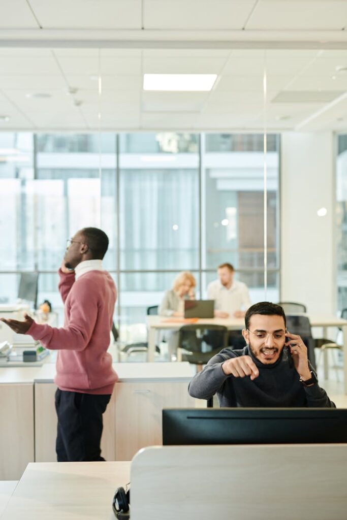 Dynamic office environment featuring diverse professionals engaged in teamwork and multitasking on phone calls.